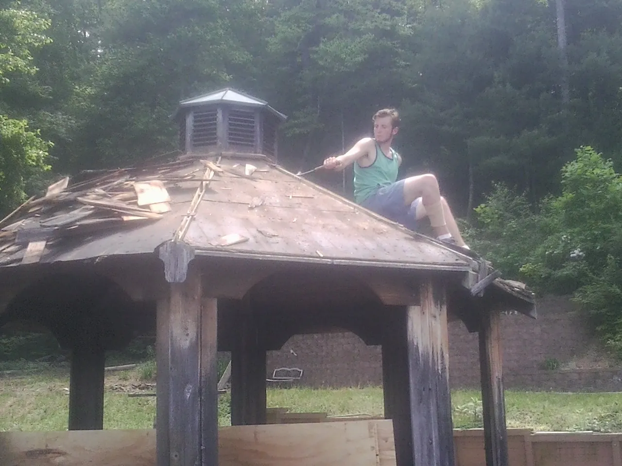 Tearing the old roof off a wooden gazebo before new shakes in Indian Mound