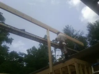 Carpenter setting a ridge beam over a new addition frame — Ice Dam Removal by Roofing Brothers in Indian Mound