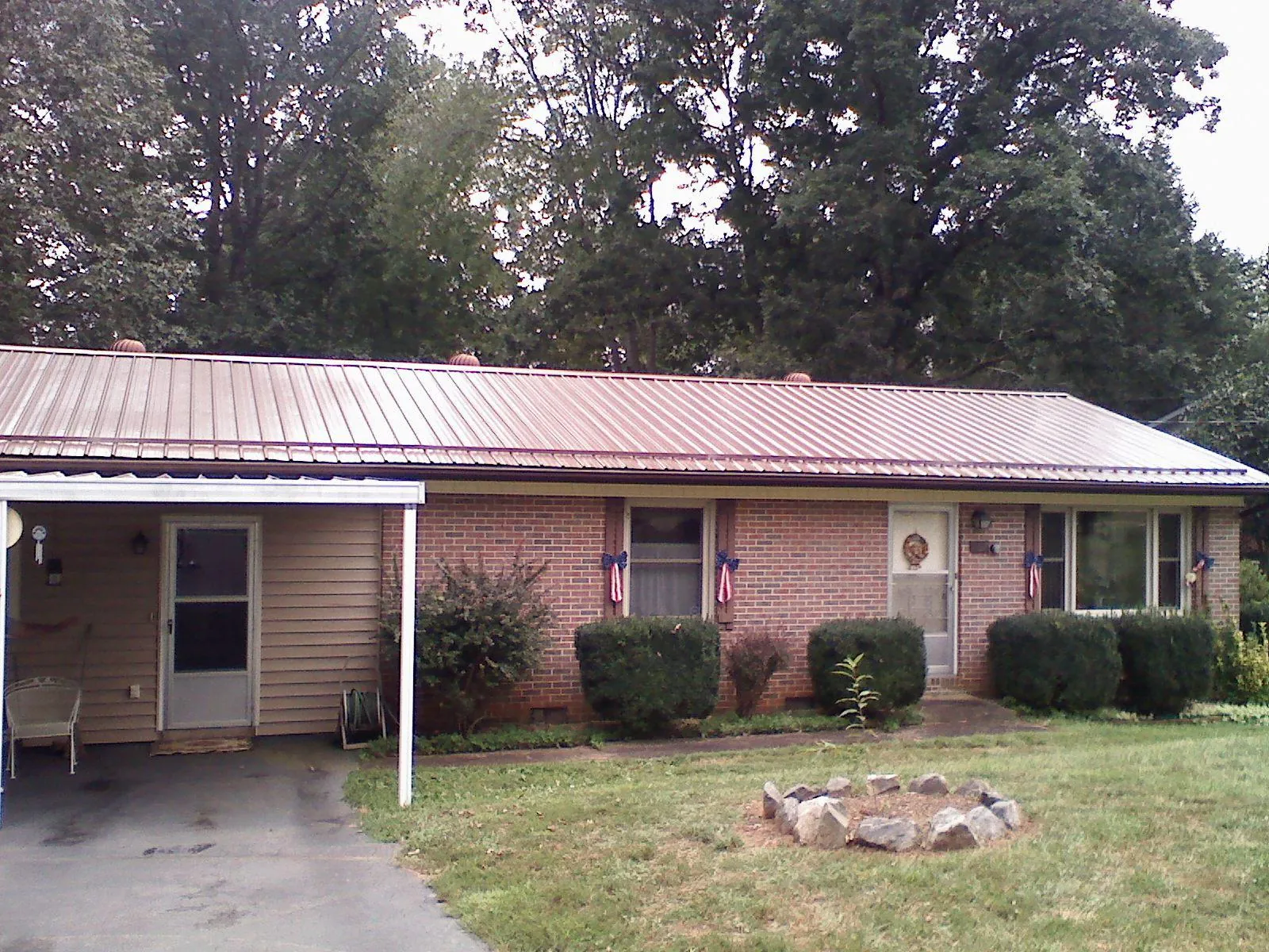 Bronze metal roof and carport on a brick ranch home — Roof Repair work by our crew in Indian Mound