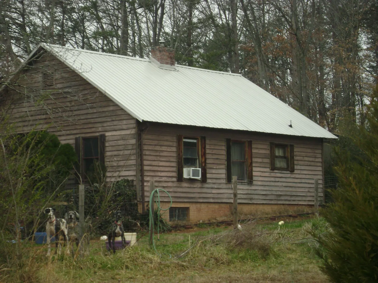 White metal roof on an old wood sided farmhouse, from a Metal Roof Installation job in Indian Mound